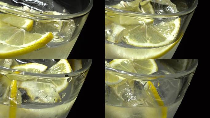 Glass of water with ice and lemon in rotation