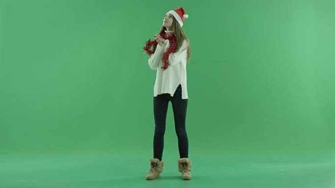 戴着圣诞帽的漂亮宝贝在相机上摆姿势，背景上有色键