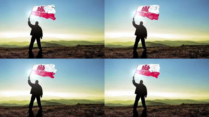 成功的剪影男子胜利者挥舞直布罗陀旗帜在山顶。Cinemagraph循环背景