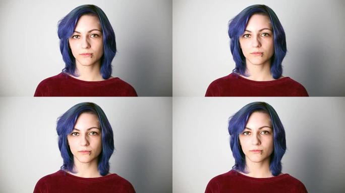 现代青年。一个严肃的女孩的平静肖像，外表异常，有着蓝色的头发和穿孔。