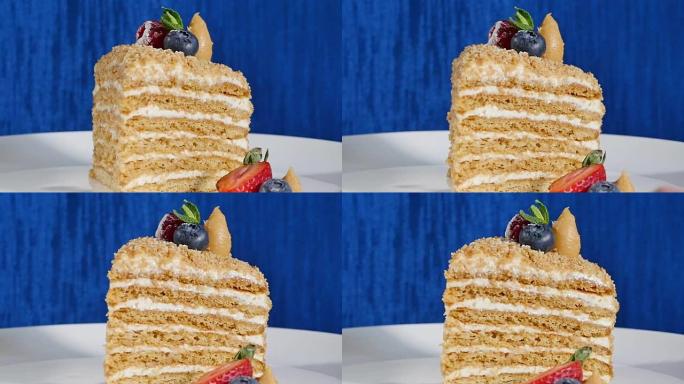 盘子上有草莓和蓝莓的分层蛋糕。夏季浆果蛋糕。多层浆果和开心果慕斯蛋糕