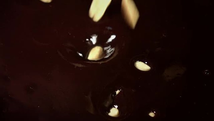 花生在真实慢动作中掉入巧克力的视频