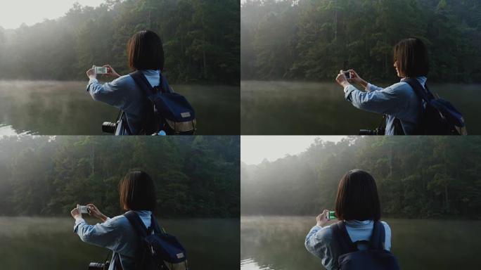 女人在美丽的大自然中使用智能手机拍照