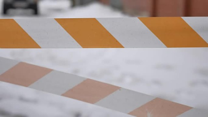橙色和白色，条纹保护胶带保护新鲜水泥，修复工作。工业艺术背景冬季事故施工户外