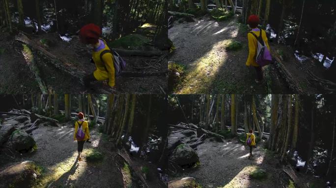 一位活跃的健康时髦女孩-摄影师手里拿着相机走过森林。低调60 FPS慢动作。GoPro 6黑色，带三