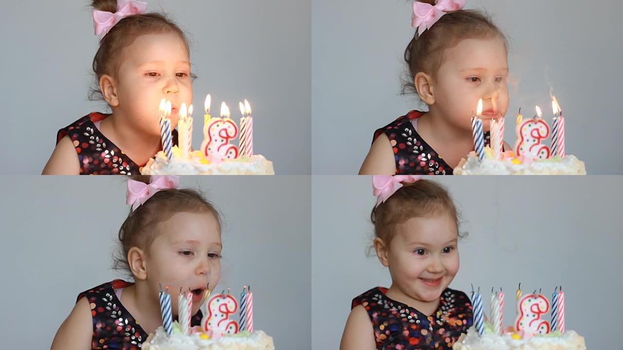 有趣的快乐孩子在派对上吹灭生日蛋糕上的蜡烛。可爱的小女孩。儿童假期的概念。3年