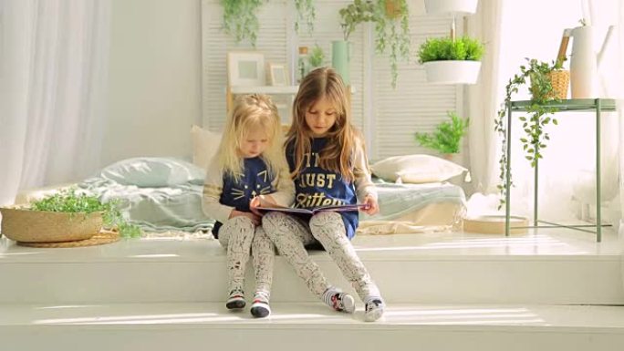 两个小女孩在一个有植物的明亮房间里读书