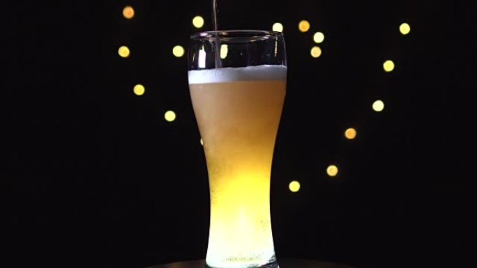 啤酒正从顶部倒入玻璃杯中。一品脱啤酒正在旋转