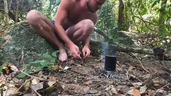 高加索野蛮人在热带森林里烧火，用米饭烧水壶当晚餐。