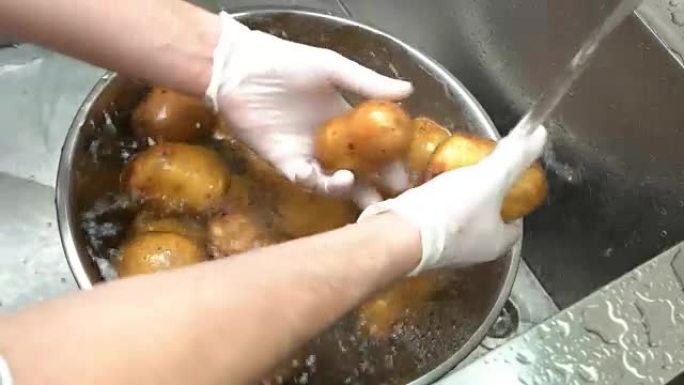 手在水槽里洗土豆。
