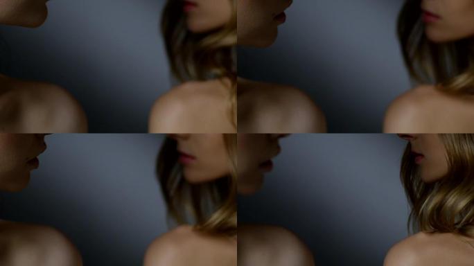 黑发和金发时装模特的身体上部 (背部，肩膀，脖子，锁骨，下巴，嘴巴) 的特写。模特们互相看着对方。时