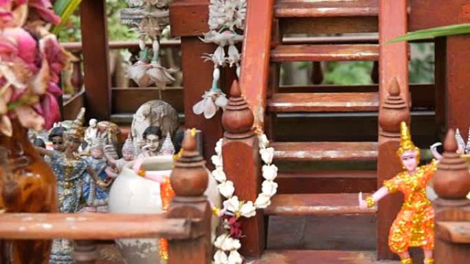 泰国花园中装饰精美的传统佛教祭坛，鲜花和各种象征性人物