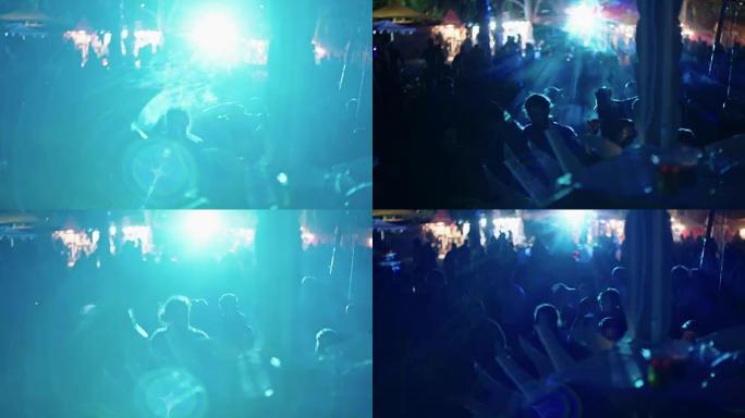 DJ在一个大型户外舞会上播放音乐，人们在跳舞