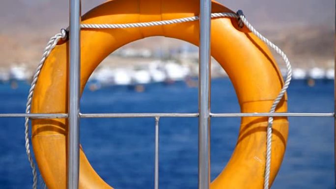 夏天，大海，橙色救生圈，挂在渡轮上，船上。船的特殊救援设备。拯救一个溺水的人的生命