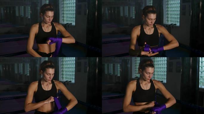 泰拳女拳击手在黑暗的房间里用烟雾打斗之前，手上缠着紫色绷带