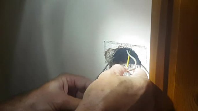 男人在房子里换电源插座。