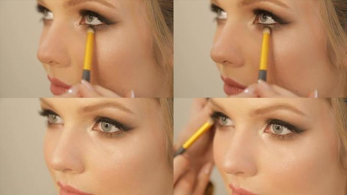 艺术家-化妆将明亮的基本颜色眼影涂在女孩的眼睛上