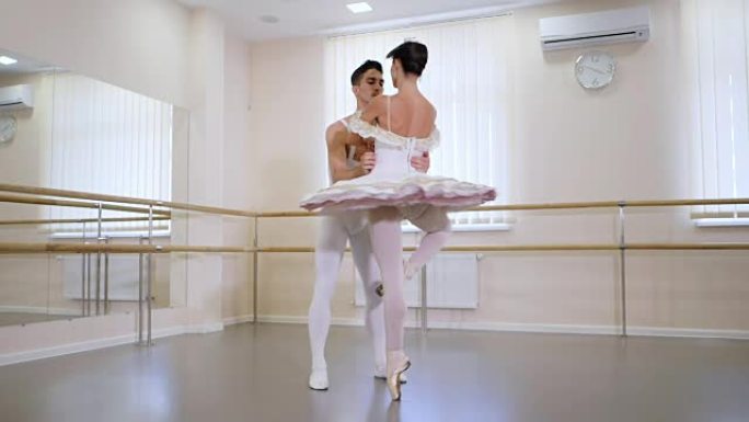 专业的，情感的芭蕾舞演员在健身房或大厅里练习，室内简约。夫妇在表演前跳了一段感性的舞蹈。慢动作