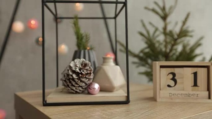 时尚的圣诞斯堪的纳维亚内部细节。北欧新年装饰舒适之家。花瓶中的冷杉树枝，带有12月31日人物的木制立