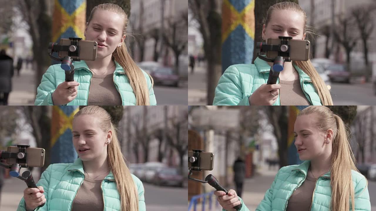 带手机摄像头稳定器的女孩视频记录器为视频日志制作视频
