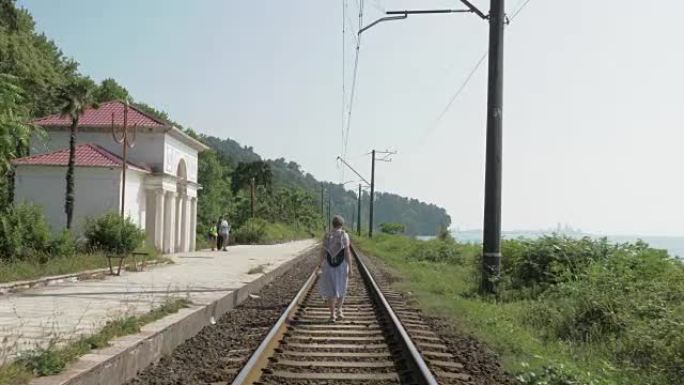 年轻女孩走在铁路上。格鲁吉亚