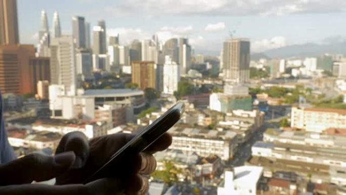 飞越一名男子在手机上打字，俯瞰一座现代化城市