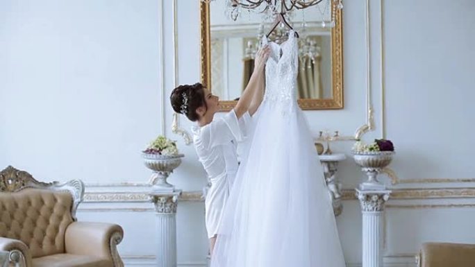 穿着长袍的美丽新娘正在看婚纱
