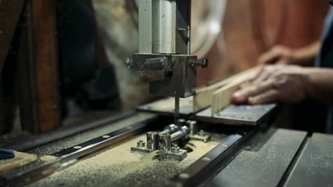 Luthier forms a billiard cue running on a band saw