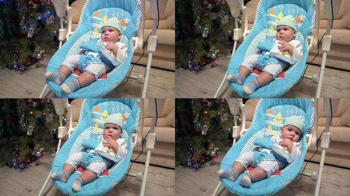 新生男孩在自动电动婴儿椅上摇摆