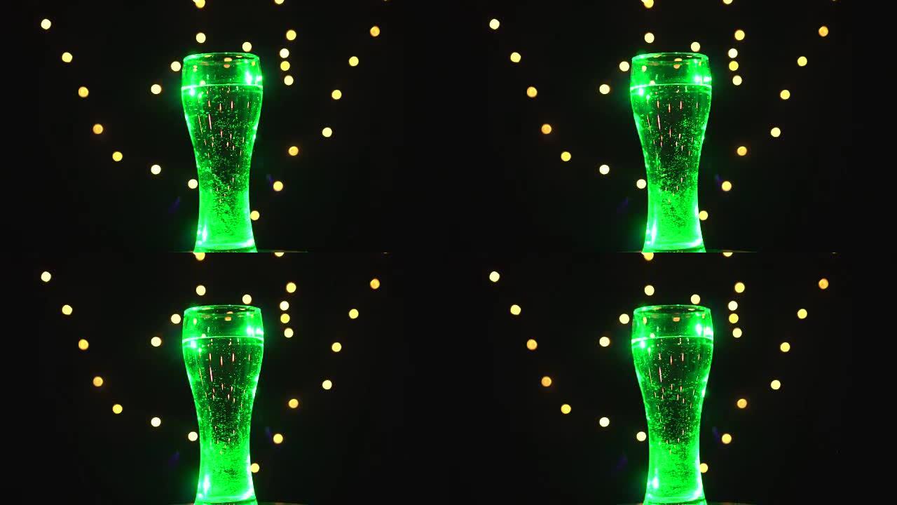 浅绿色灯光下的一杯水正在旋转。绿色鸡尾酒。酒吧概念