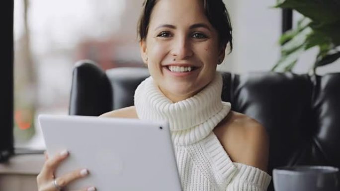 微笑的女人在咖啡馆里使用平板电脑