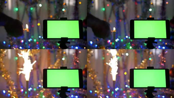 带有绿色屏幕的智能手机，在新年背景上。该男子点燃节日烟花