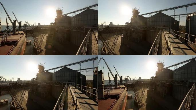 晴天海港谷物码头全景。谷物从泊位的大型电梯散装转运到散装船上装载谷物作物的船只。农产品运输