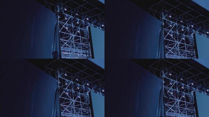 一个修理音乐会设备的人的剪影。舞台工作者设置灯光