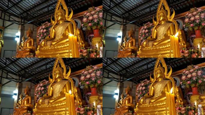 蜡烛在寺庙金佛雕像的背景上燃烧。芭堤雅。泰国