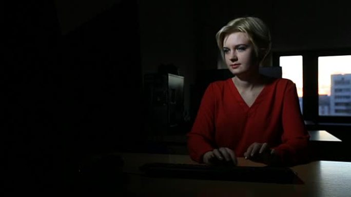 在计算机上工作的学生女孩，窗户日落直到深夜在教室或校园图书馆dolly拍摄