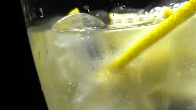 Glass of water with ice and lemon in rotation