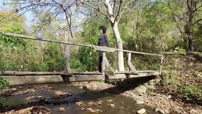 运动女子在木桥上的森林徒步旅行，steadicam徒步射击