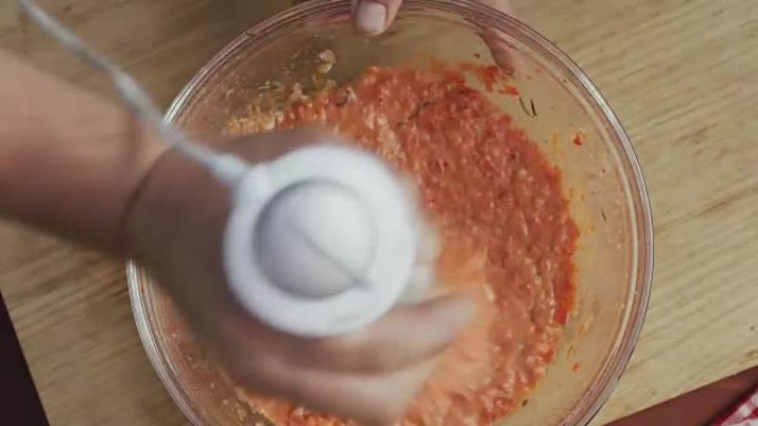 A chef is using blender to make a pepper purèe
