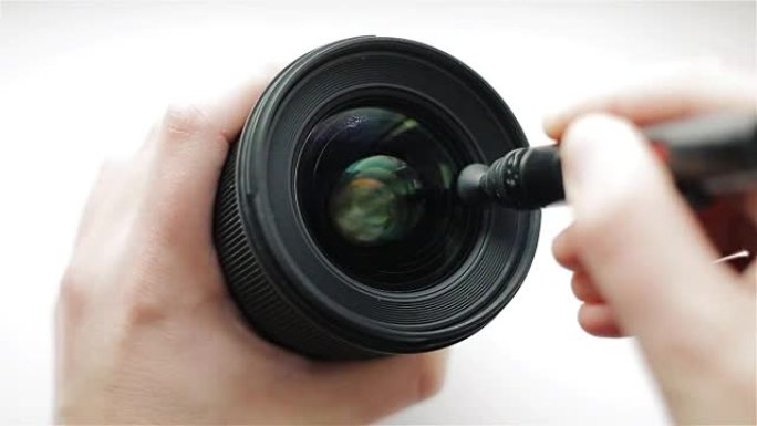 经验丰富的摄影师或视频操作员使用专业的光学清洁手柄对摄影镜头的前玻璃进行密集清洁，以防止灰尘和指纹