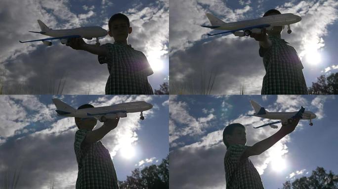 快乐的少年男孩在美丽的天空背景下玩玩具飞机