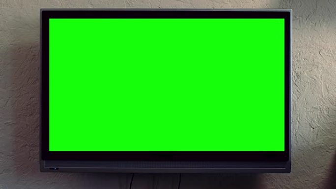 纯平电视与绿屏合成。电视或电视-绿屏-房间-在墙上。现代客厅带轨道绿屏的液晶电视