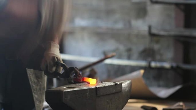 铁匠铺锻造铁水。打碎，拧，锻造热熨斗。手工制作。