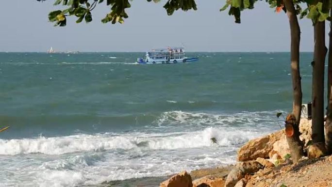 海浪袭击了岸上的大石头。通过客运渡轮