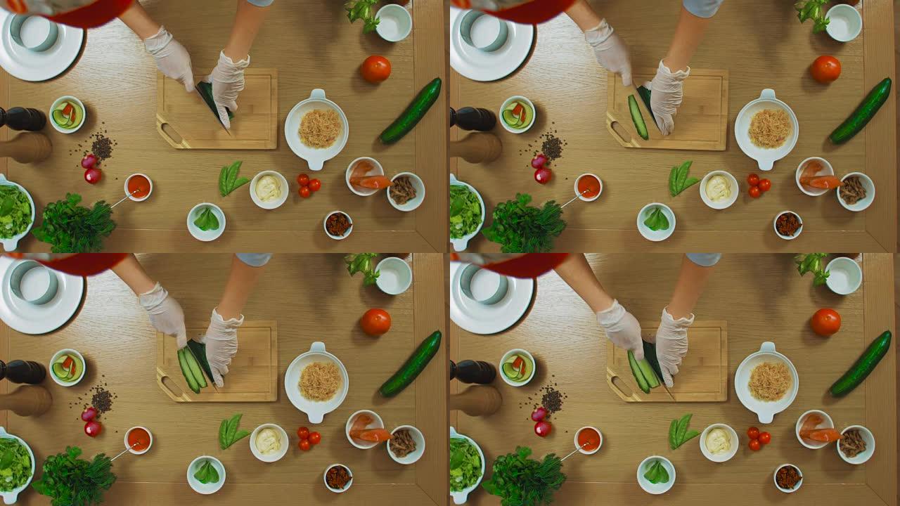 女性手切黄瓜、番茄、鱼、牛至、酱汁、奶酪的俯视图