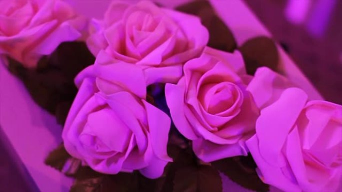 鲜花婚礼餐桌装饰。桌上的婚礼鲜花。人造玫瑰装饰婚礼餐桌。花束。庆祝活动