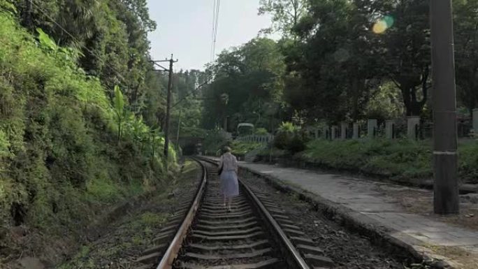年轻女孩走在铁路上。格鲁吉亚