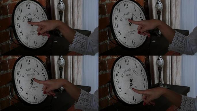 女人和时钟。女性的手在时钟的表盘上。