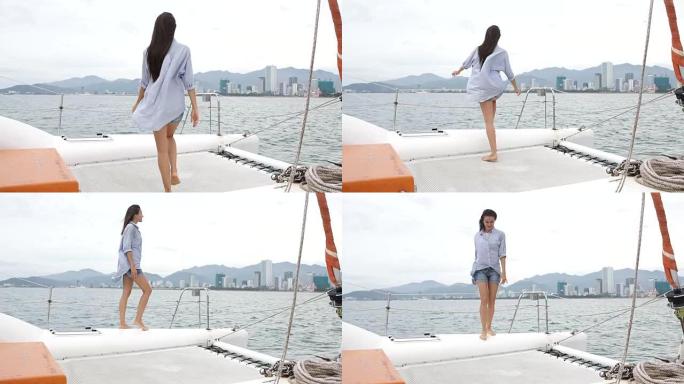 年轻女子在享受双体船巡游时看着大海