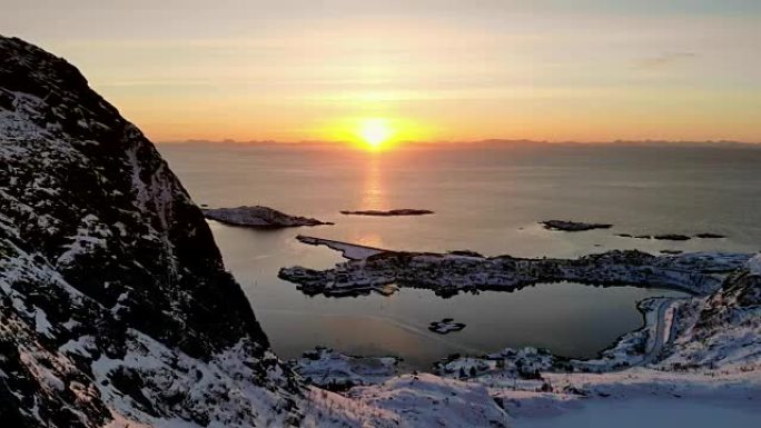 冬季日出时在北极海岸线上的斯堪的纳维亚村庄的鸟瞰图。挪威罗弗滕群岛Reine村